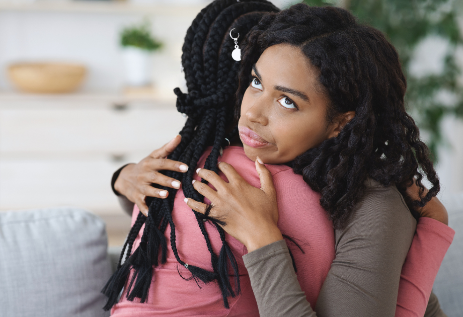 two women hugging. One of the women are rolling their eyes